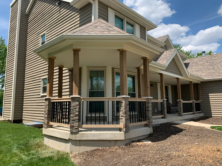 Covered porch addition with stone-clad railing posts and siding matched to the existing home, Naperville IL