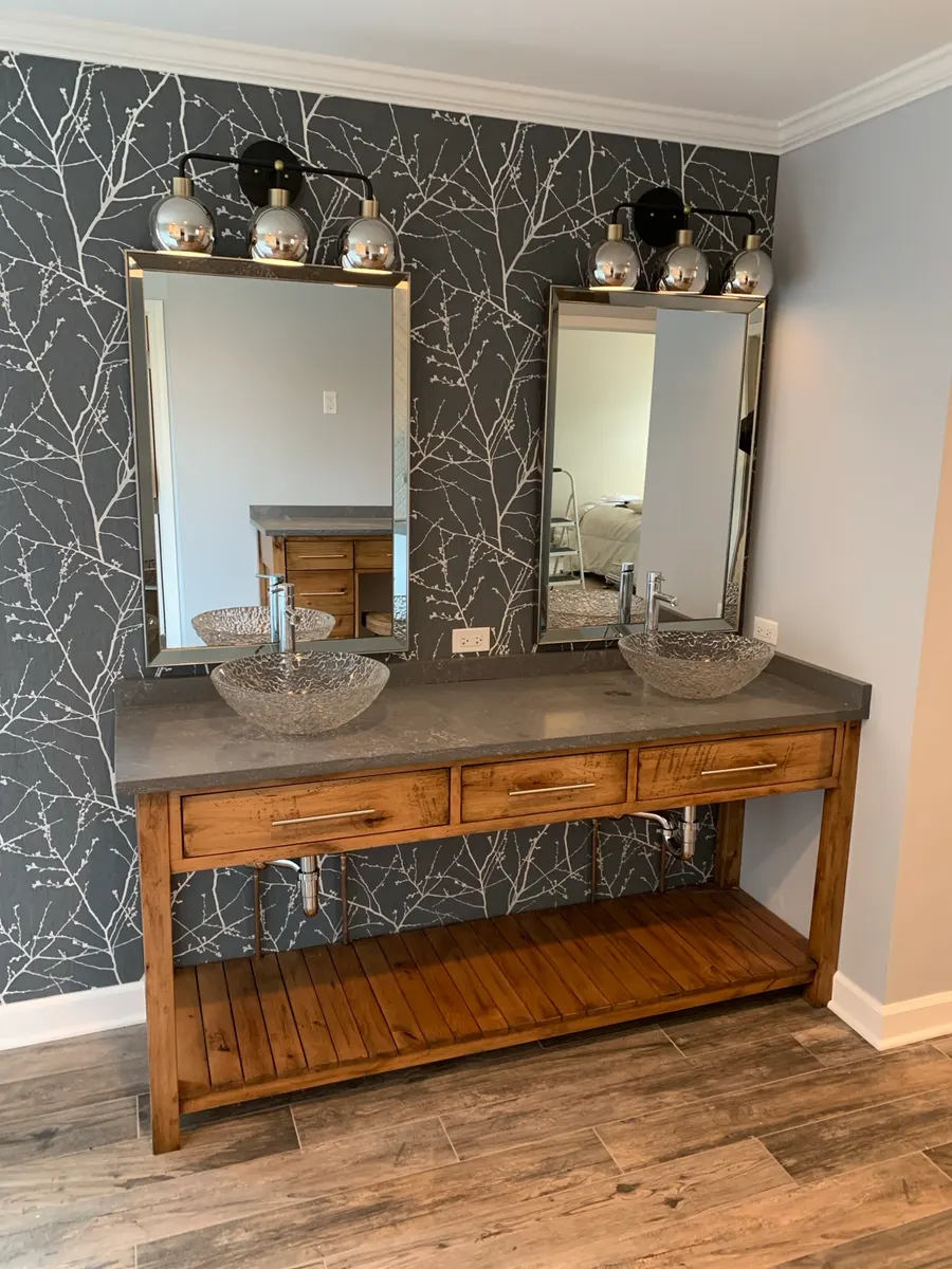 Dual-vanity bathroom with charcoal branch-print wallpaper, glass vessel sinks, and stained wood cabinetry, Naperville IL