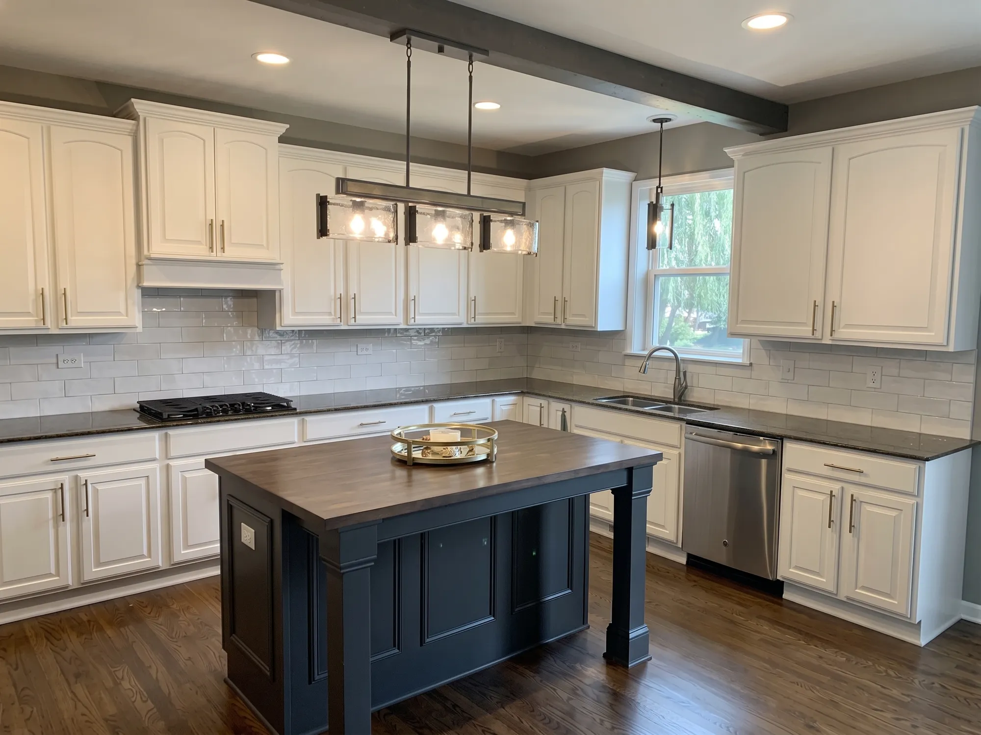 Custom kitchen remodel in Naperville, IL with white shaker cabinetry and navy butcher-block island