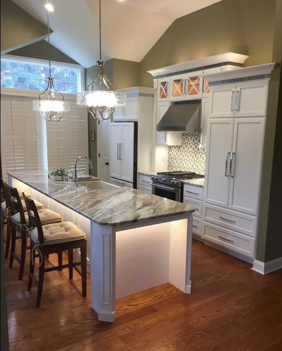 Kitchen remodel with vaulted ceiling, white raised-panel cabinetry, and quartzite waterfall island, Naperville IL