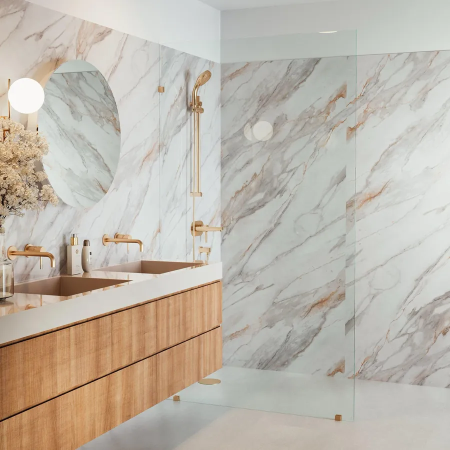 Pannello XL marble-look waterproof wall panels in a shower, with brass fixtures and a wood vanity